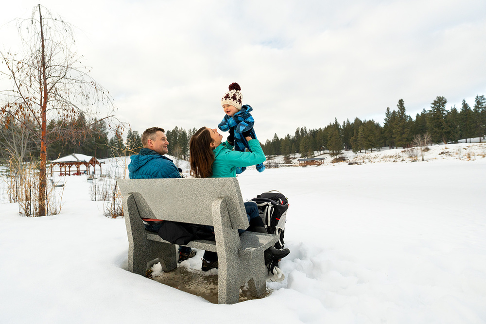 A Family sitting on a bench in winter